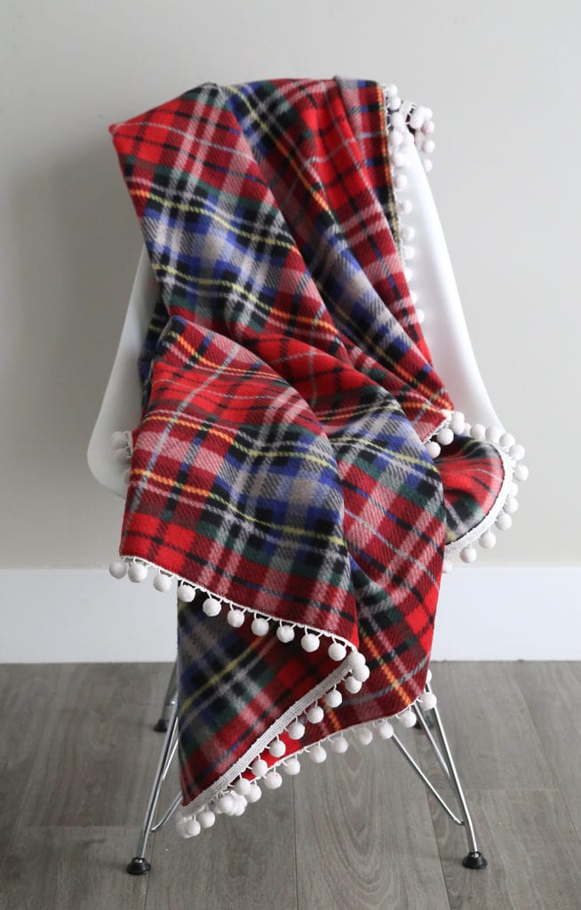 20+ Christmas Sewing Projects featured by top US craft blogger, Sweet Red Poppy: It's Always Autumn Fleece Blanket With Pom Pom Trim Sewing Tutorial