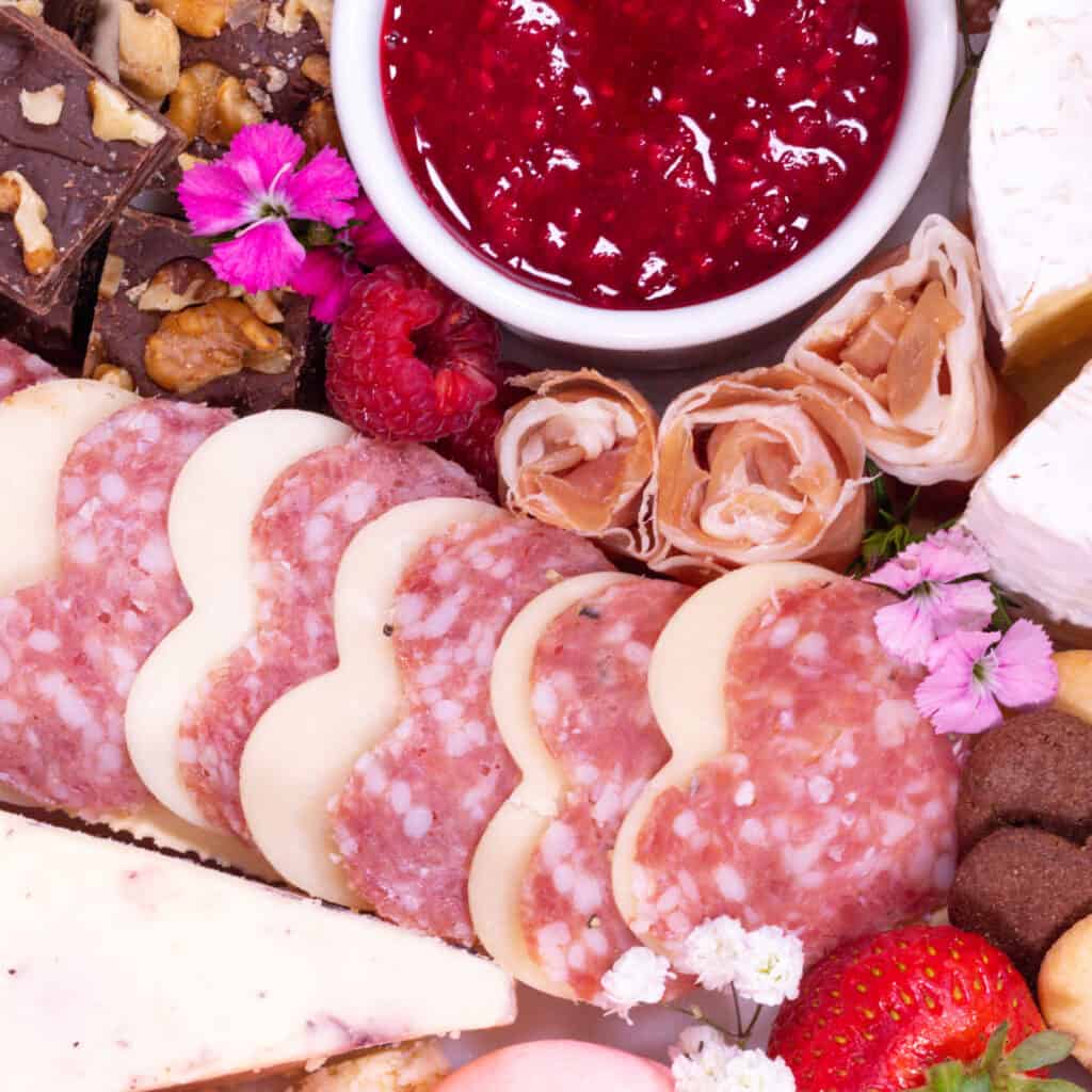 Valentine's Day Charcuterie Board by popular Utah craft blog, Sweet Red Poppy: image of a charcuterie board filled with meat, crackers, cheeses, macaroons, nuts, and fruit. 