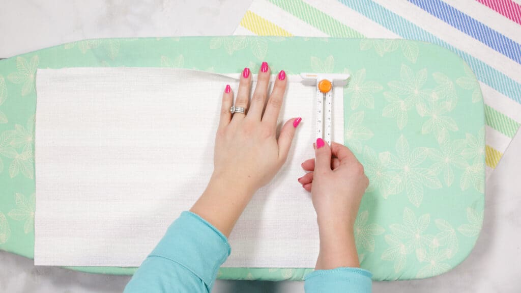 Iron Fabric for Envelope Pillowcase |How to Make an Envelope Pillow Cover With One Piece of Fabric by popular Utah sewing blog, Sweet Red Poppy: image of a woman folding over the edge of some fabric. 