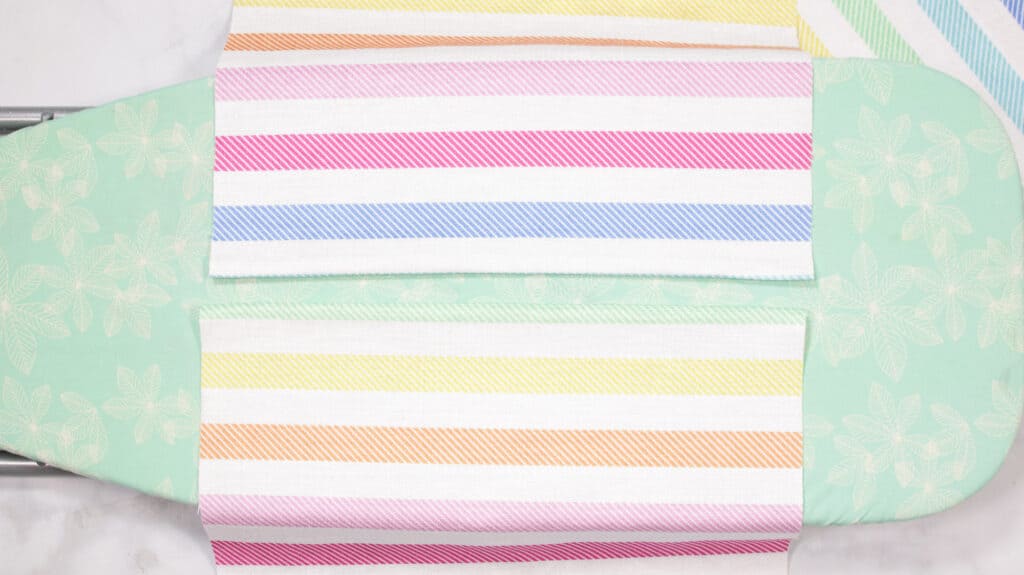 How to Make an Envelope Pillow Cover With One Piece of Fabric by popular Utah sewing blog, Sweet Red Poppy: image of rainbow stripe fabric on a ironing board. 