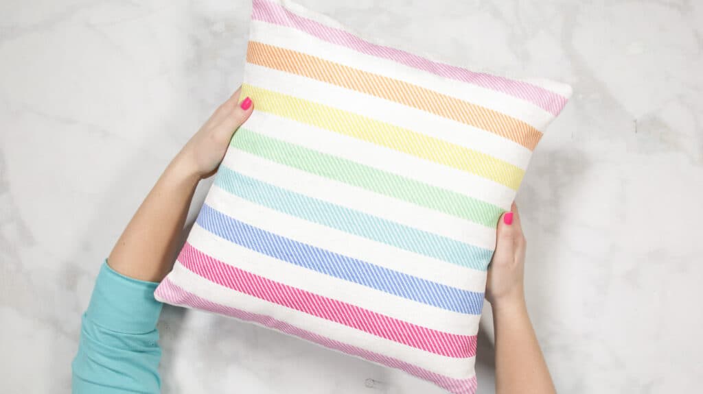 How to Make an Envelope Pillow Cover With One Piece of Fabric by popular Utah sewing blog, Sweet Red Poppy: image of a rainbow stripe pillow cover. 