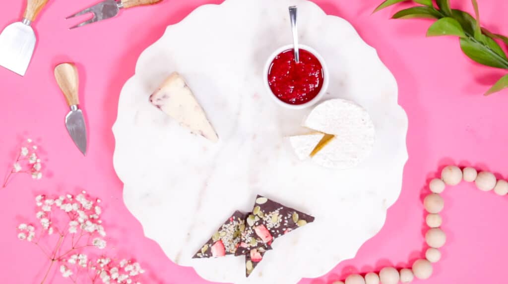 Valentine's Day Charcuterie Board by popular Utah craft blog, Sweet Red Poppy: image of a white marble board set with fruit preserves, chocolate, and cheese. 