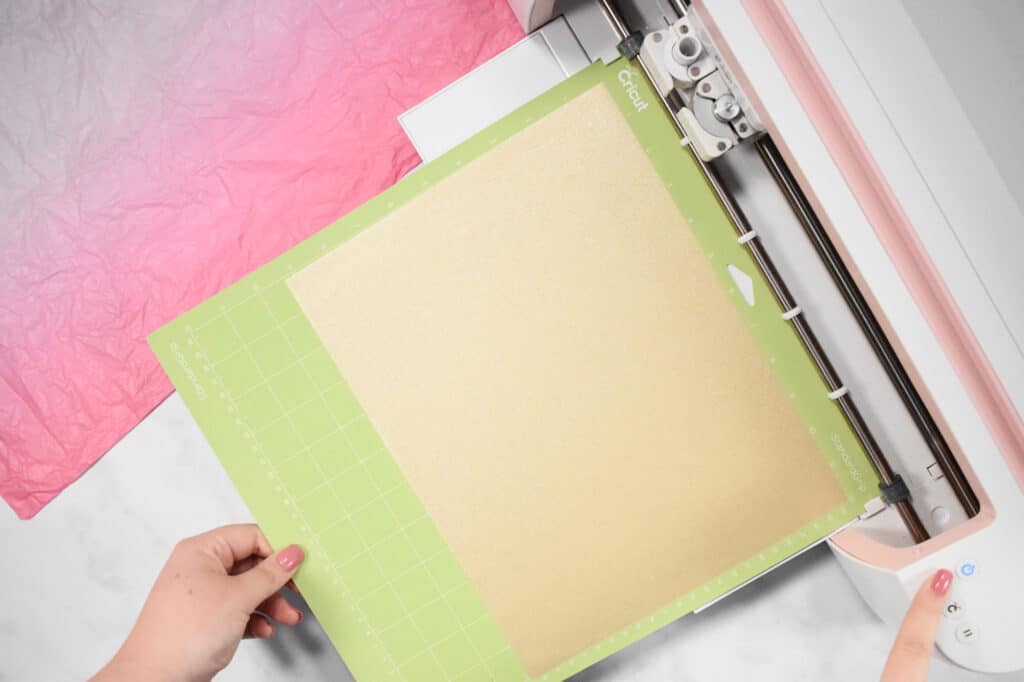 Cricut Shadow Box by popular US craft blog, Sweet Red Poppy: image of  a woman putting gold glitter vinyl into their Cricut machine. 