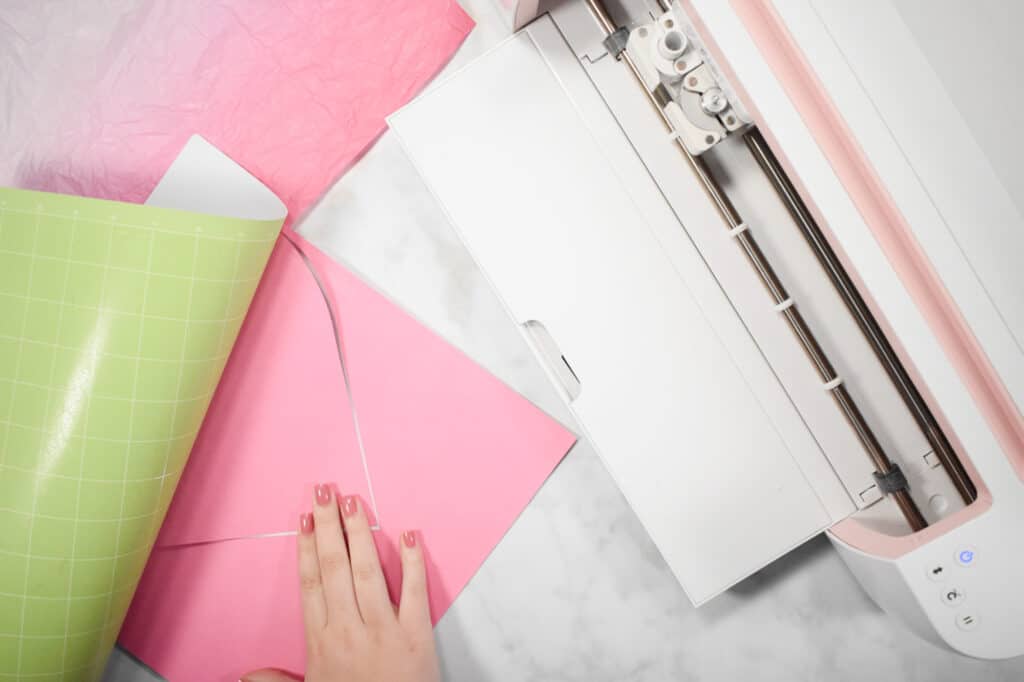 Cricut Shadow Box by popular US craft blog, Sweet Red Poppy: image of  a woman removing a paper heart from a Cricut mat. 