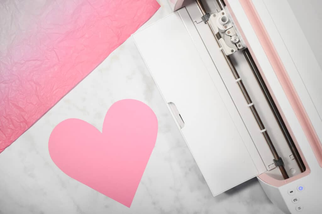 Cricut Shadow Box by popular US craft blog, Sweet Red Poppy: image of  a paper heart next to a Cricut machine. 