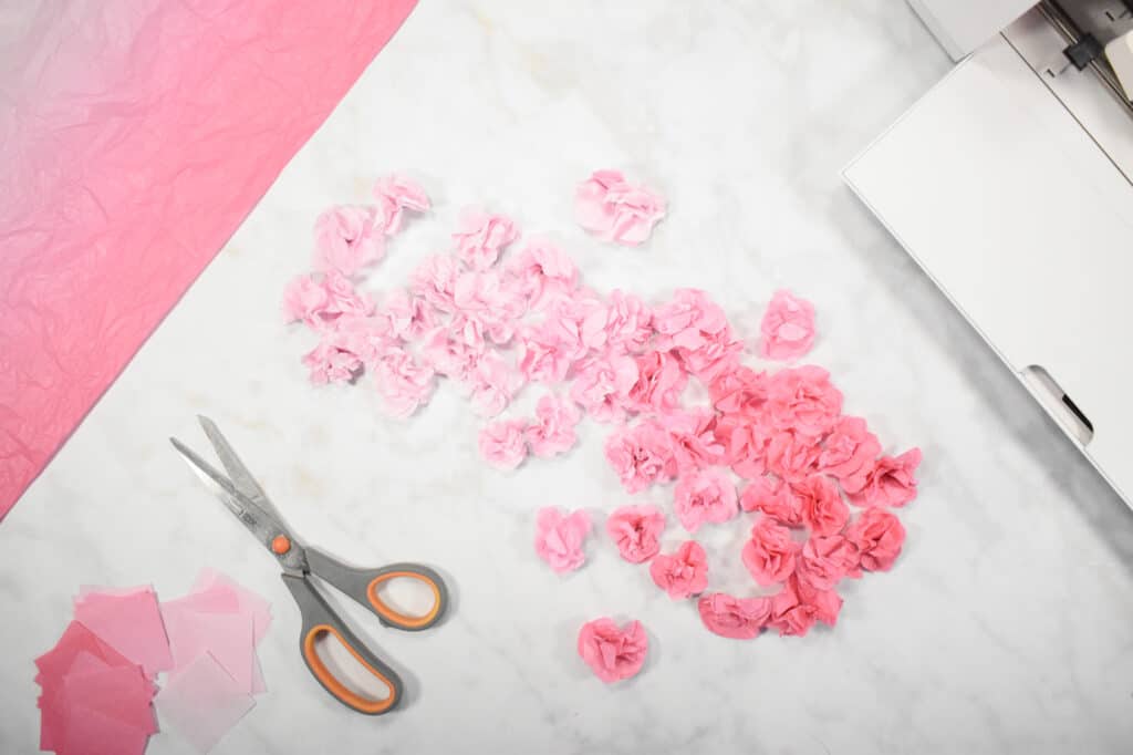 Cricut Shadow Box by popular US craft blog, Sweet Red Poppy: image of  pink paper flowers next to some grey handle scissors. 