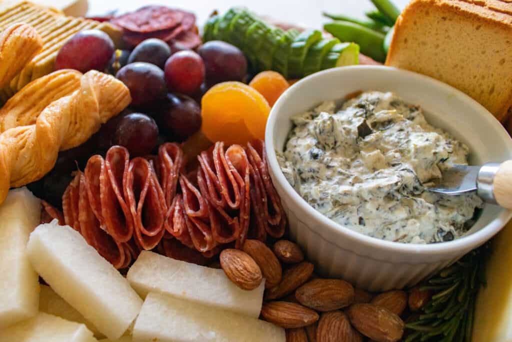 Learn How to Assemble a Charcuterie Board Filled With Cheese, Meats, Crackers, Nuts, Fruits & Vegetables. |How to Assemble a Charcuterie Board by popular Utah craft blog, Sweet Red Poppy: image of a charcuterie board filled with cheese, nuts, fruit, meat, crackers, dips, vegetables, and yogurt dipped pretzels. 