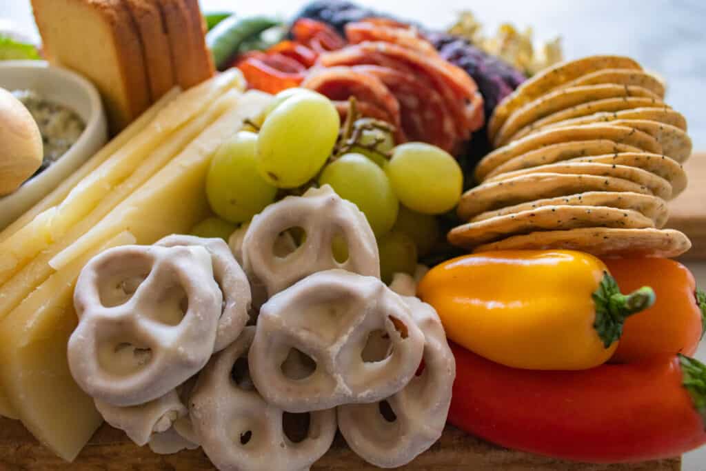 How to Assemble a Charcuterie Board by popular Utah craft blog, Sweet Red Poppy: image of a charcuterie board filled with cheese, nuts, fruit, meat, crackers, dips, vegetables, and yogurt dipped pretzels. 