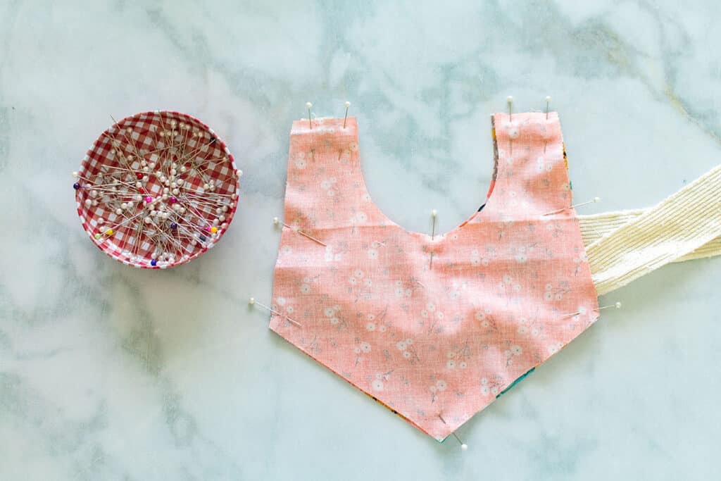 Baby Bib Sewing Pattern by popular US sewing blog, Sweet Red Poppy: image of fabric bib pieces pinned in place with fabric pins. 