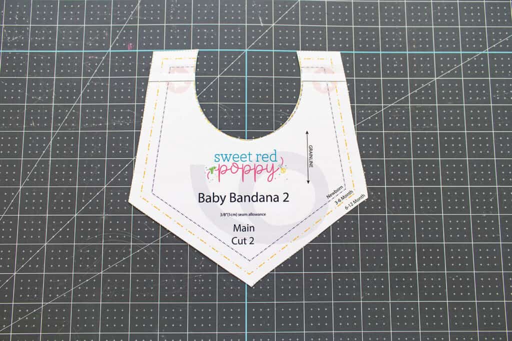 Baby Bib Sewing Pattern by popular US sewing blog, Sweet Red Poppy: image of a bib pattern on a rotary mat. 
