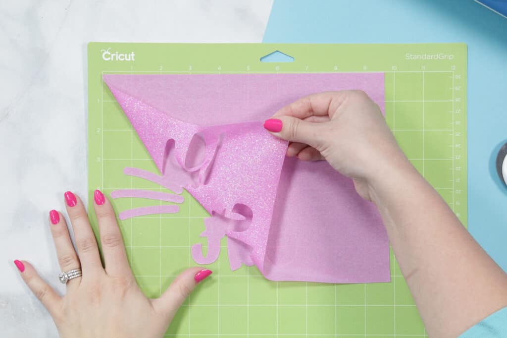 I'm not a cat SVG file | SVG Files by popular US craft blog, Sweet Red Poppy: image of a woman peeling pink glitter vinyl off a green Cricut mat. 
