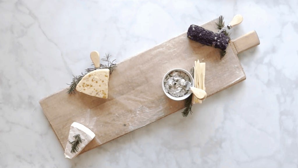 How to Assemble a Charcuterie Board by popular Utah craft blog, Sweet Red Poppy: image of various cheeses on a wooden board. 