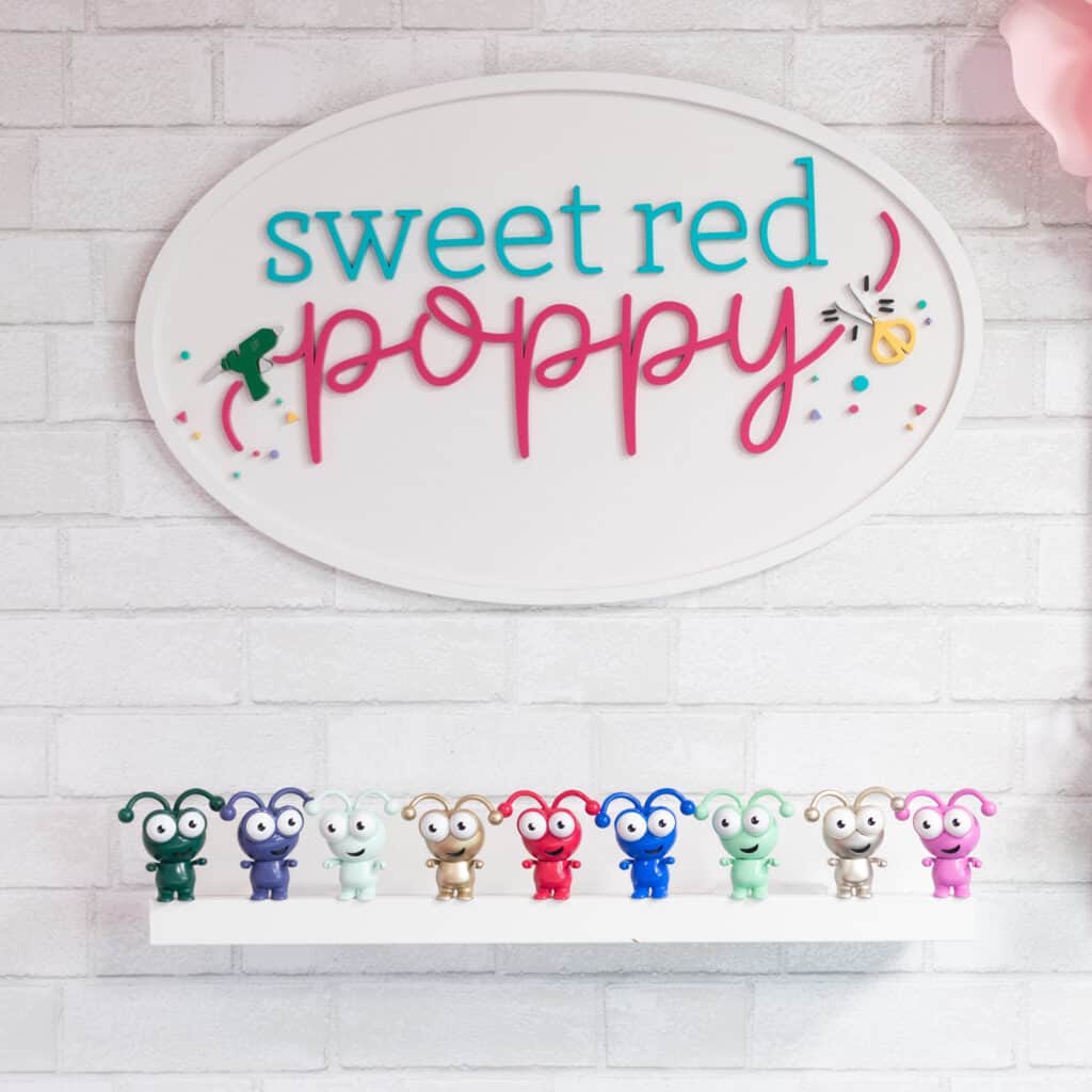 Cricut Mystery Box by popular Utah craft blog, Sweet Red Poppy: image of Cricut cuties on a white floating shelf under a Sweet Red Poppy sign. 