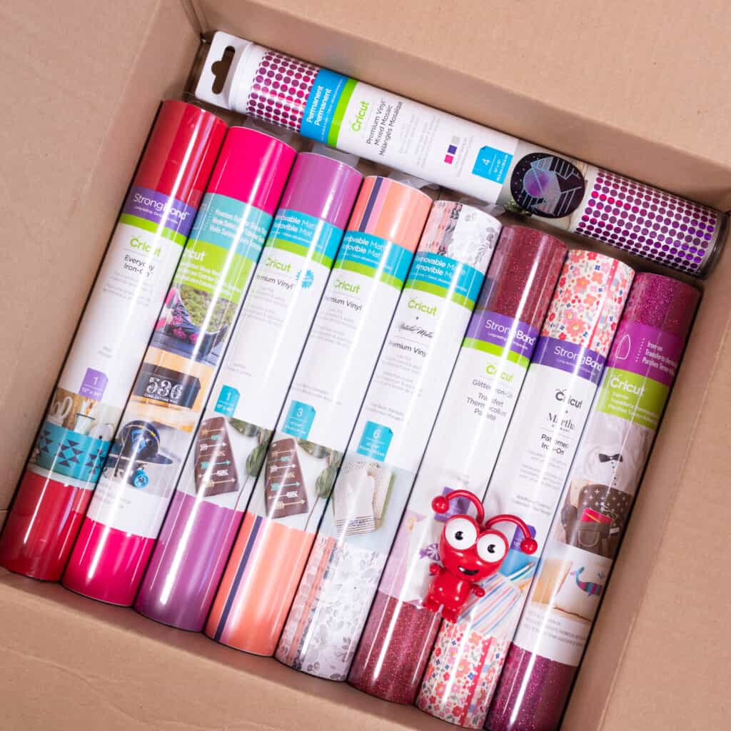 Cricut Mystery Box by popular Utah craft blog, Sweet Red Poppy: image of a cardboard box filled with Cricut iron-on vinyl and a Cricut cutie. 