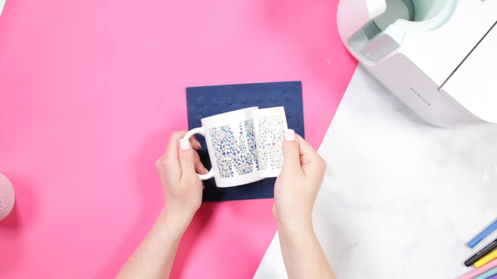 Cricut Infusible Ink Pens by popular US craft blog, Sweet Red Poppy: image of a woman holding a white ceramic mug and peeling off the backing of a design. 
