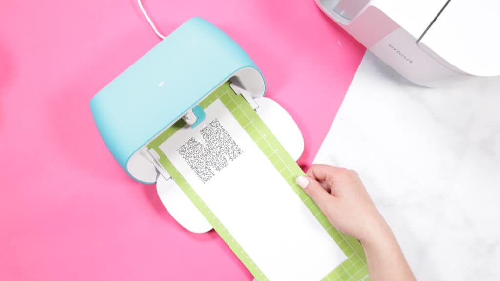 Cricut Infusible Ink Pens by popular US craft blog, Sweet Red Poppy: image of a woman placing a stand grip mat into a machine. 