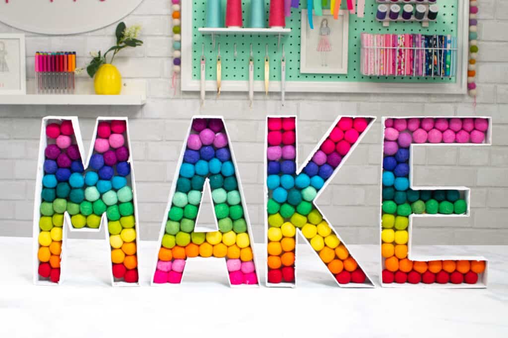 Create These Easy DIY Felt Ball Letters for Your Craft Room, Playroom, Nursery, and More With This Step-by-Step Tutorial Featuring Beacon's Power-Tac! | Felt Ball Letters by popular US craft blog, Sweet Red Poppy: image of rainbow felt ball letters. 