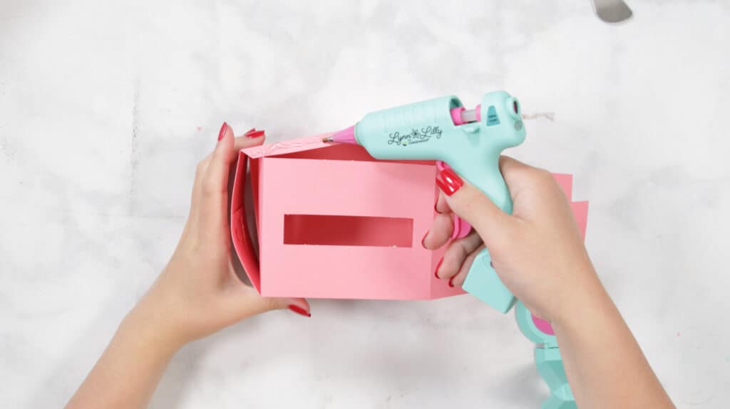 Using Hot Glue, Secure the Side of the Box |Mother's Day Mug by popular US craft blog, Sweet Red Poppy: image of a woman assembling a cutout gift box. 