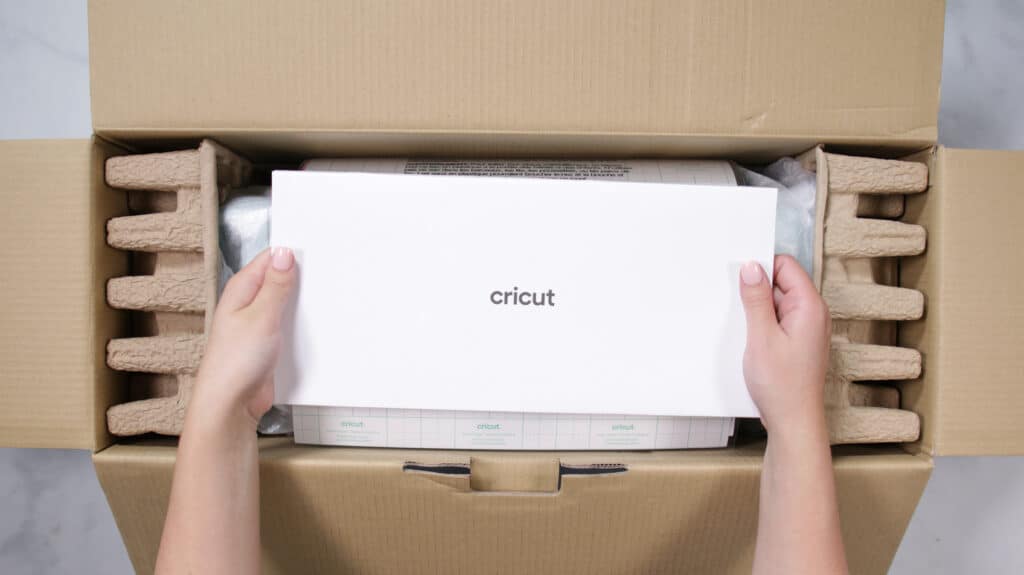 Cricute Explore 3 unboxing by top US craft blogger, Sweet Red Poppy | Cricut Explore 3 by popular US craft blog, Sweet Red Poppy: image of a woman pulling a Cricut Explore 3 out of a box. 