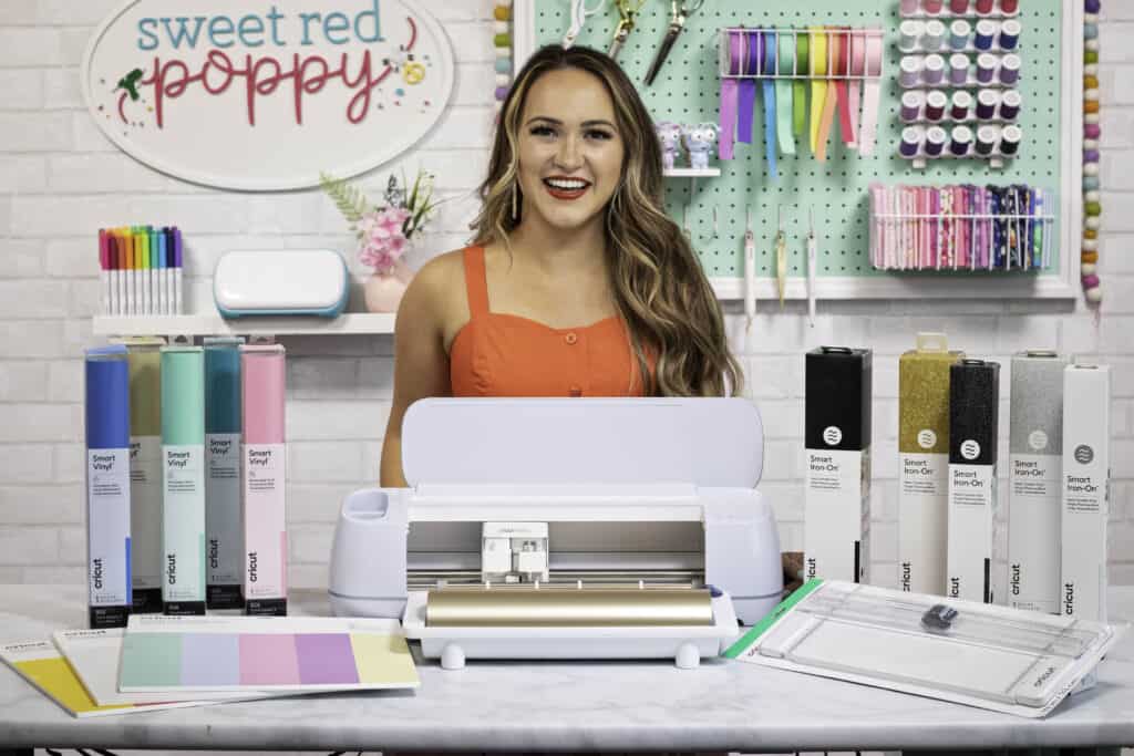 Cricut Maker 3 - Everything You Need to Know About Your New Cricut Maker 3 Machine and Smart Materials | Cricut Maker 3 by popular US craft blog, Sweet Red Poppy: image of a woman standing behind a Cricut Maker 3, Cricut smart vinyl, and Cricut paper. 