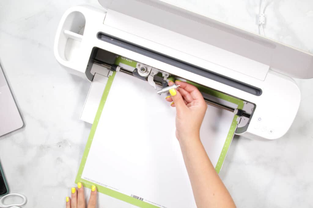 DIY 4th of July Wreath by popular US craft blog, Sweet Red Poppy: image of a woman using a Cricut machine. 