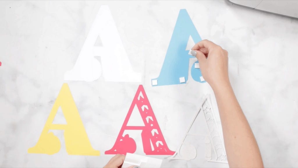 Layered Alphabet by popular US craft blog, Sweet Red Poppy: image of a woman assembling a letter a mandala. 