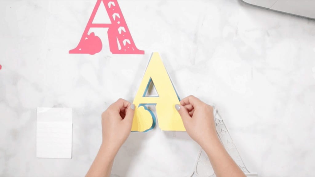 Layered Alphabet by popular US craft blog, Sweet Red Poppy: image of a woman assembling a letter a mandala. 