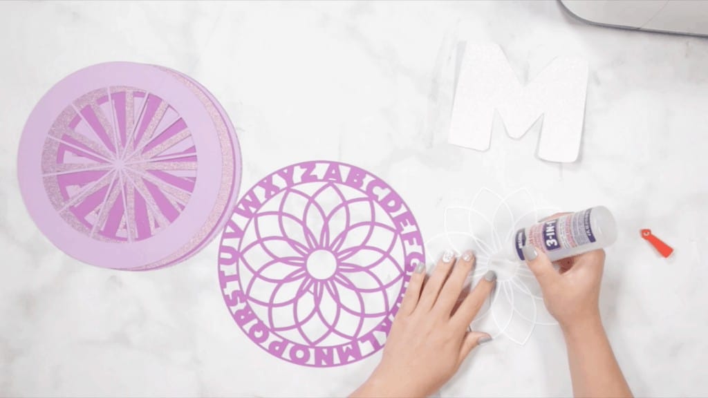 Alphabet Mandala by popular US craft blog, Sweet Red Poppy: image of a woman assembling her layered alphabet mandala. 