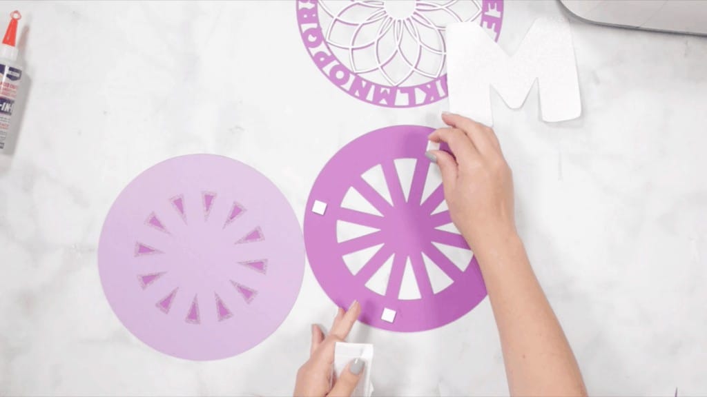 Alphabet Mandala by popular US craft blog, Sweet Red Poppy: image of a woman assembling her layered alphabet mandala. 