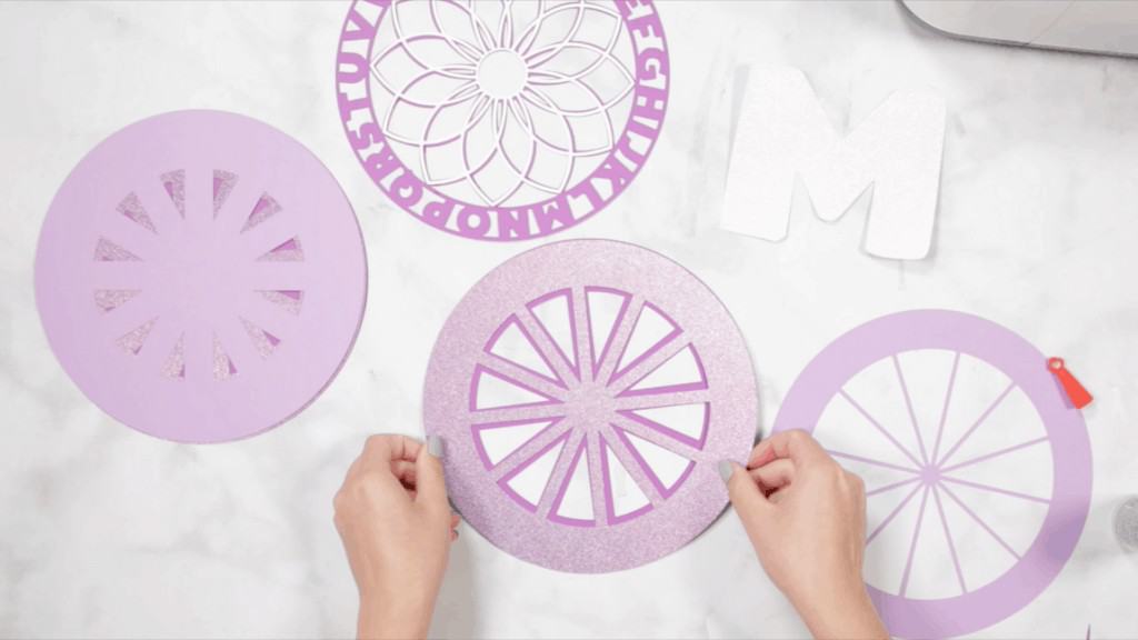 Alphabet Mandala by popular US craft blog, Sweet Red Poppy: image of a woman assembling her layered alphabet mandala. 