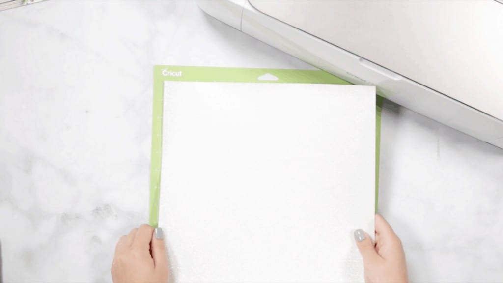 Apple Mandala by popular US craft blog, The Sweetest Thing: image of a woman placing white cardstock on a cutting mat. 