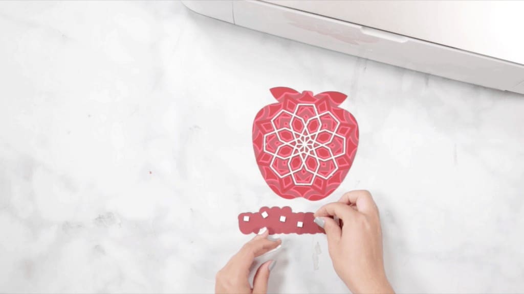 Apple Mandala by popular US craft blog, The Sweetest Thing: image of a woman assembling a layered apple mandala. 