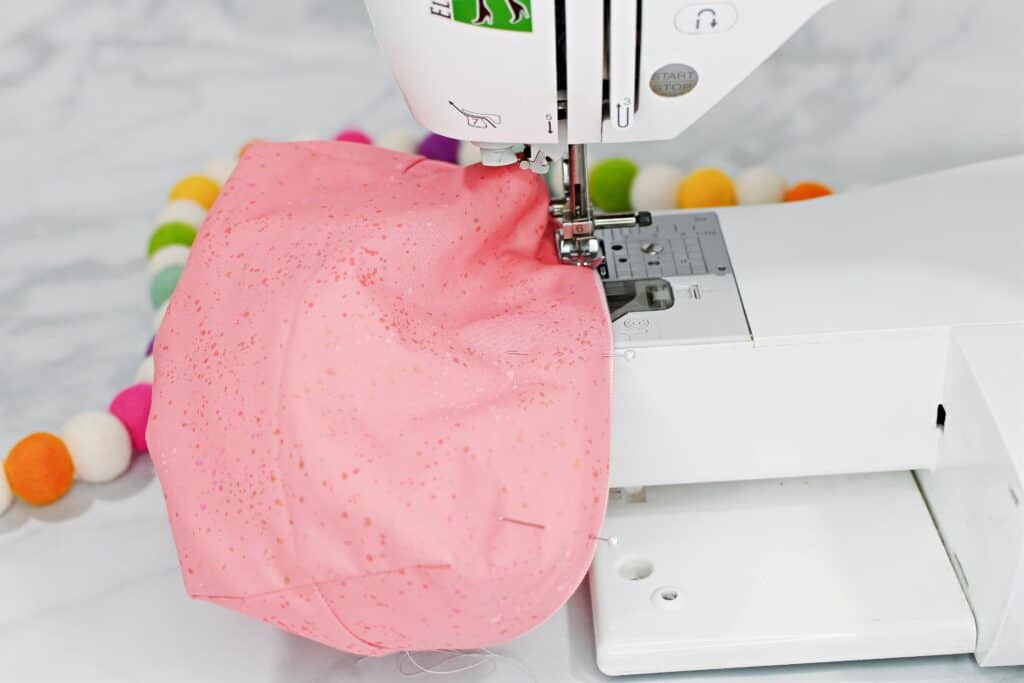 Zippered Box Pouch by popular US sewing blog, Sweet Red Poppy: image of pink fabric zippered box pouch lining being sewing on a white sewing machine. 