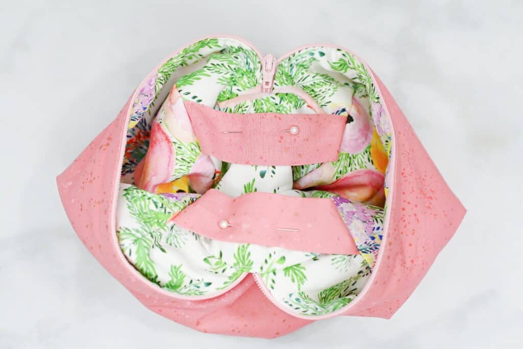 Zippered Box Pouch by popular US sewing blog, Sweet Red Poppy: image of pink fabric zippered box pouch lining being attached to floral print zippered box pouch main. 