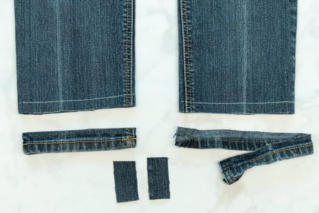 the original hem of tapered leg jeans is opened up at the inseam
