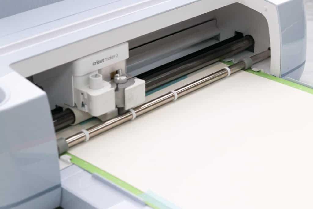 Side view of a Cricut maker 3 machine cutting a piece of cardstock