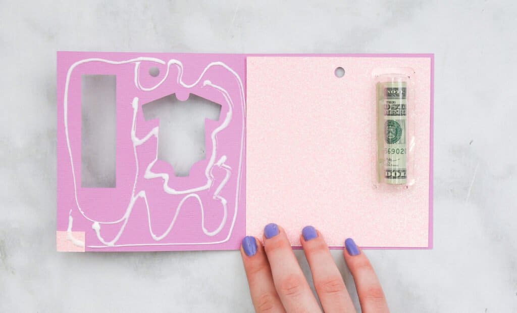 Gluing card piece to the inside of the baby shower card holder with the plastic pouch