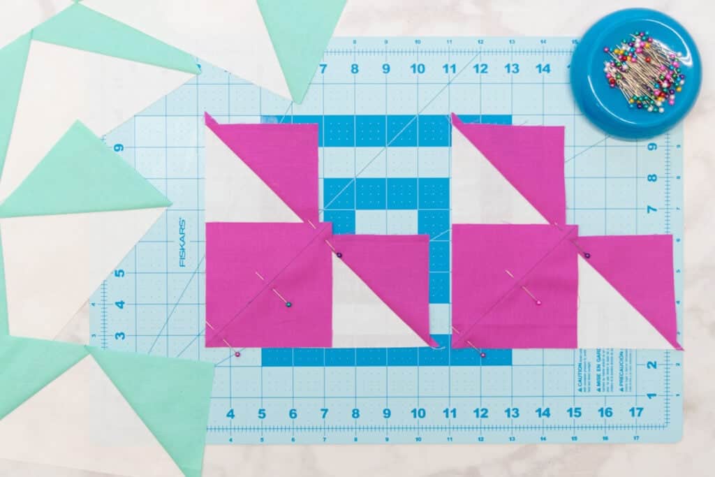 two small pink squares pinned to the white triangles