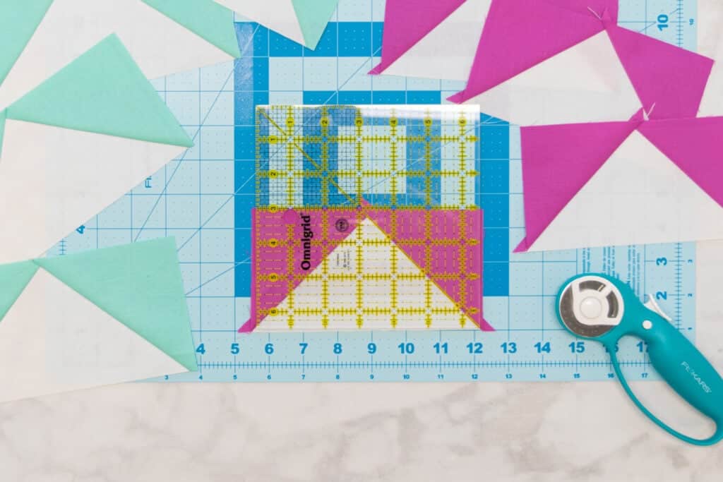 a square quilting ruler placed on an unsquared flying goose