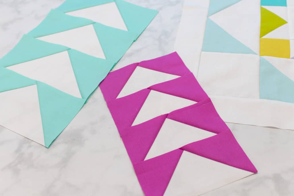 angled photo of two different colors of flying geese, pink and mint green