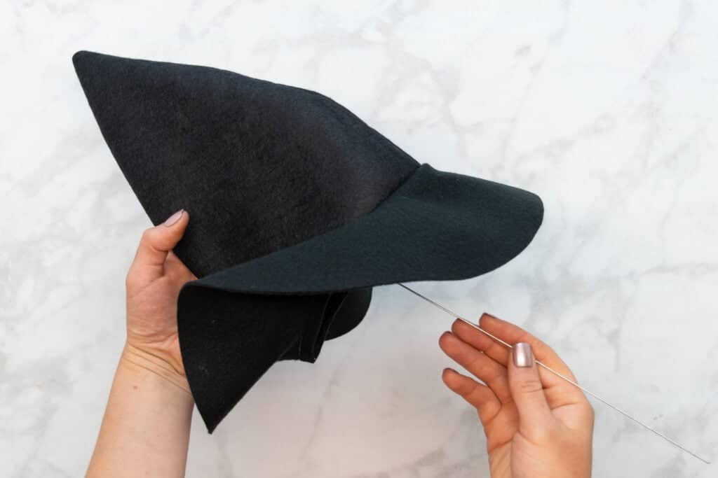 placing the wire inside the hat with the folded end at the top of the hat