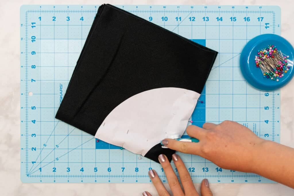 using a rotary cutter to cut along the hat brim pattern piece