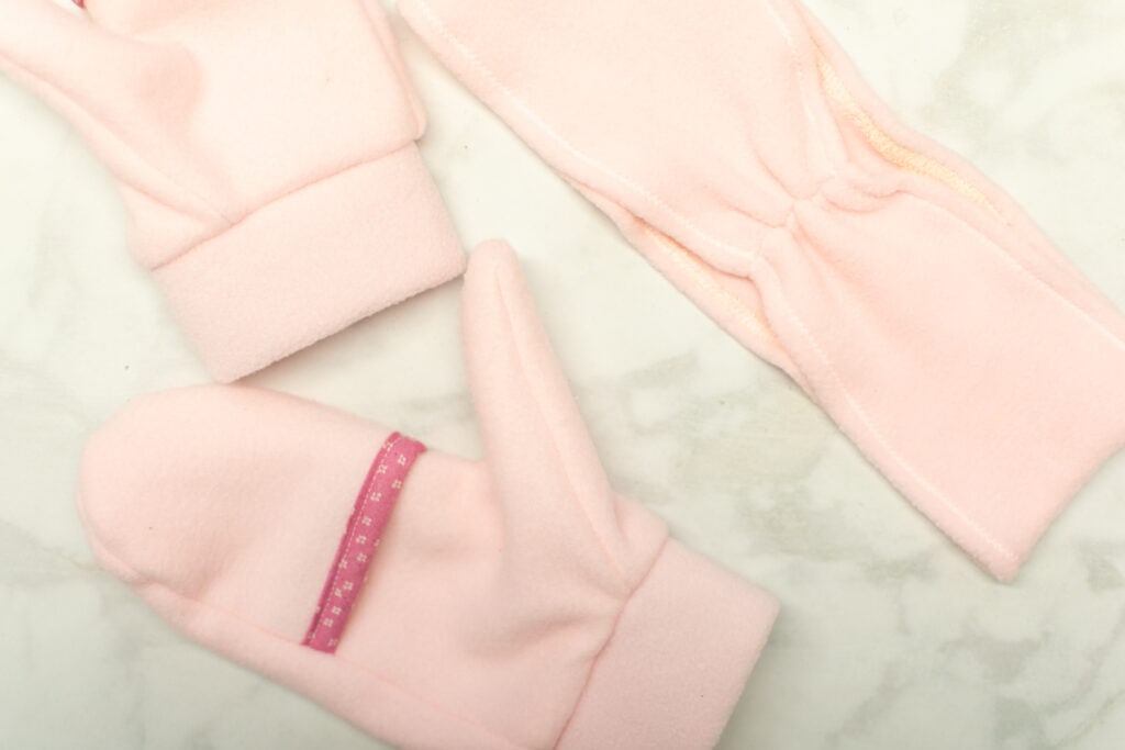 a light pink fleece headband and mittens