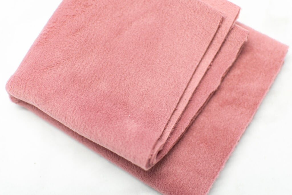thick dusty pink fleece fabric on a white background
