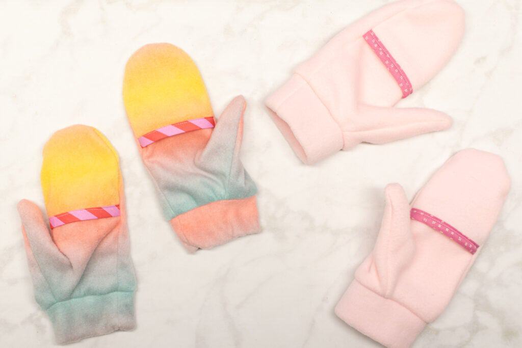 two pairs of fleece mittens, one pair light pink, the other pair yellow and pink ombre
