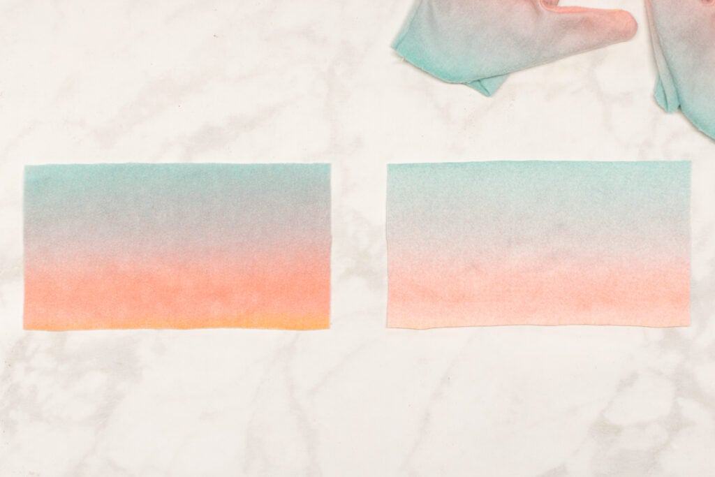 two rectangles of fleece are placed on a marble backdrop