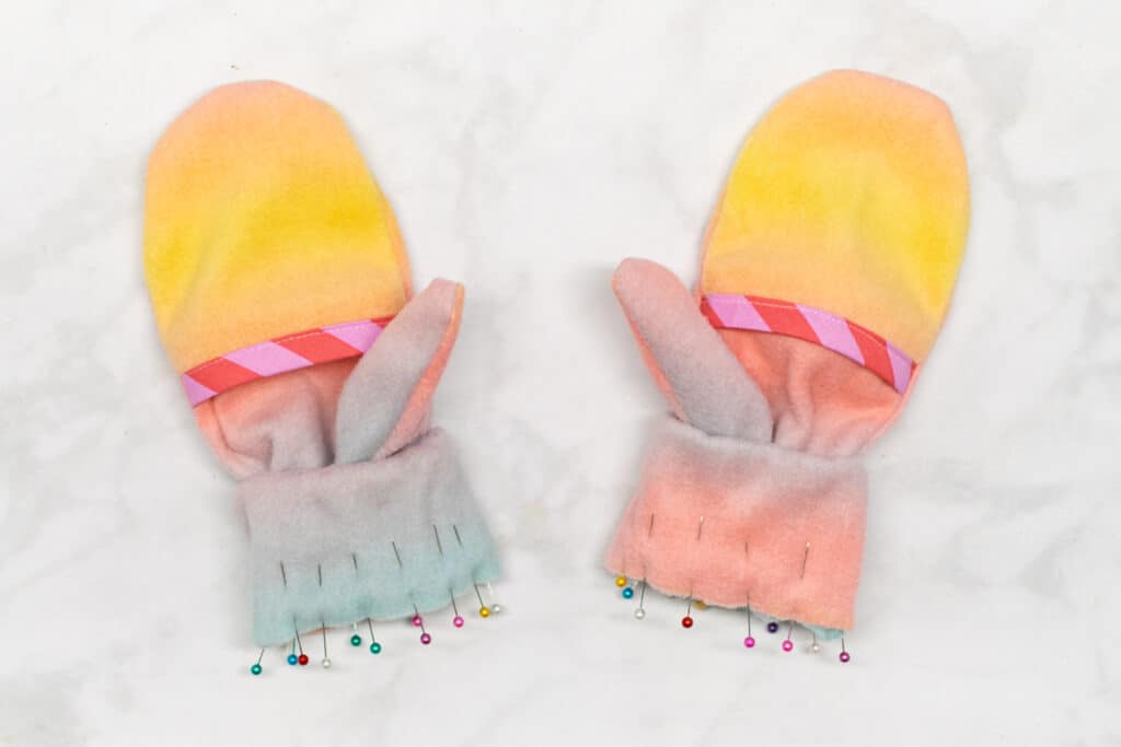 the cuffs are pinned to the wrist edges of the mittens
