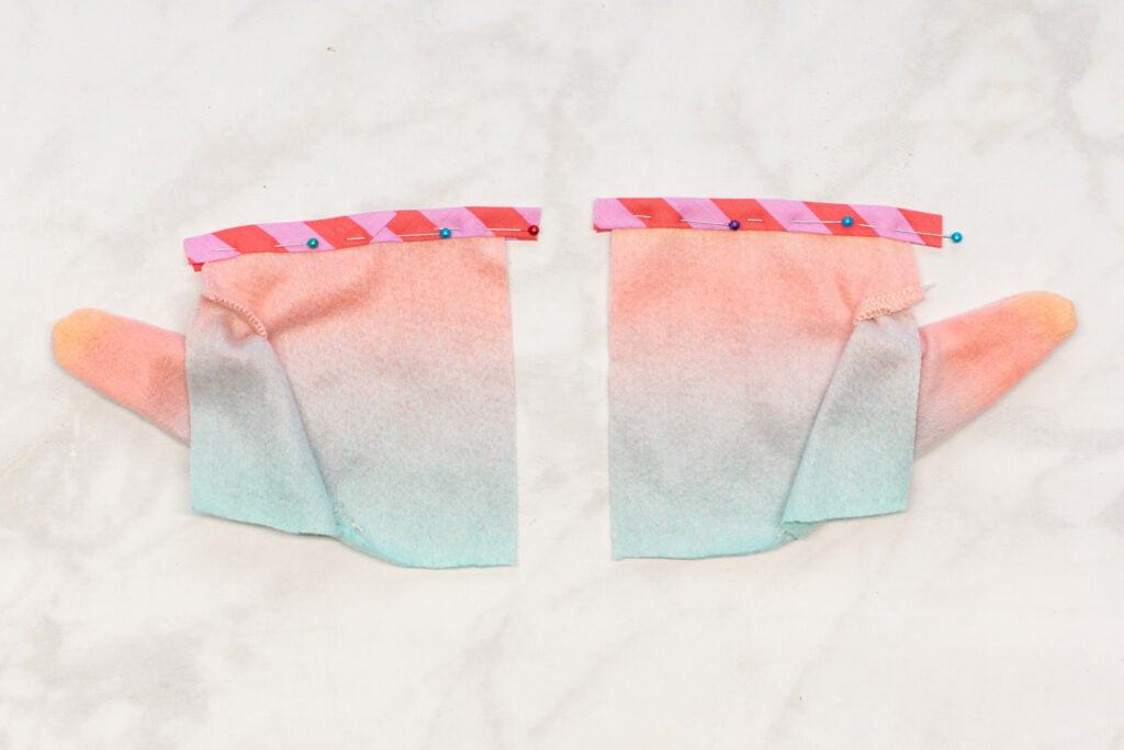a pink striped piece of bias tape is pinned to the top of each Front Bottom piece