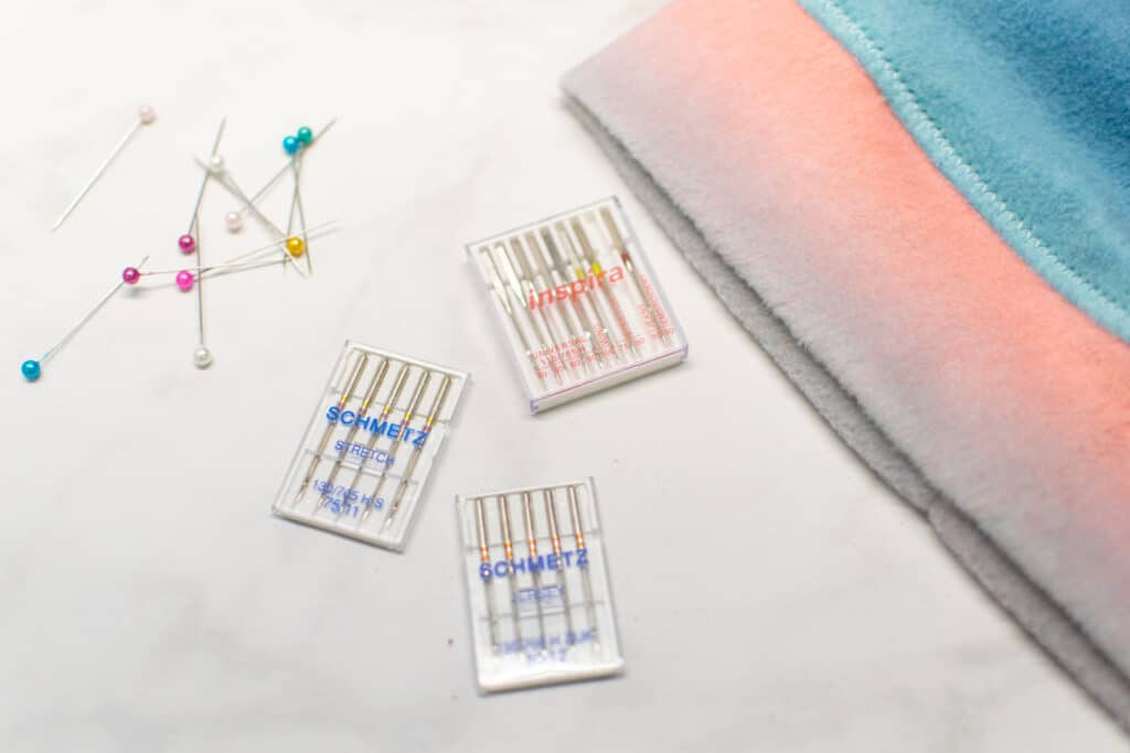 a closeup of 3 different sewing machine needle packets