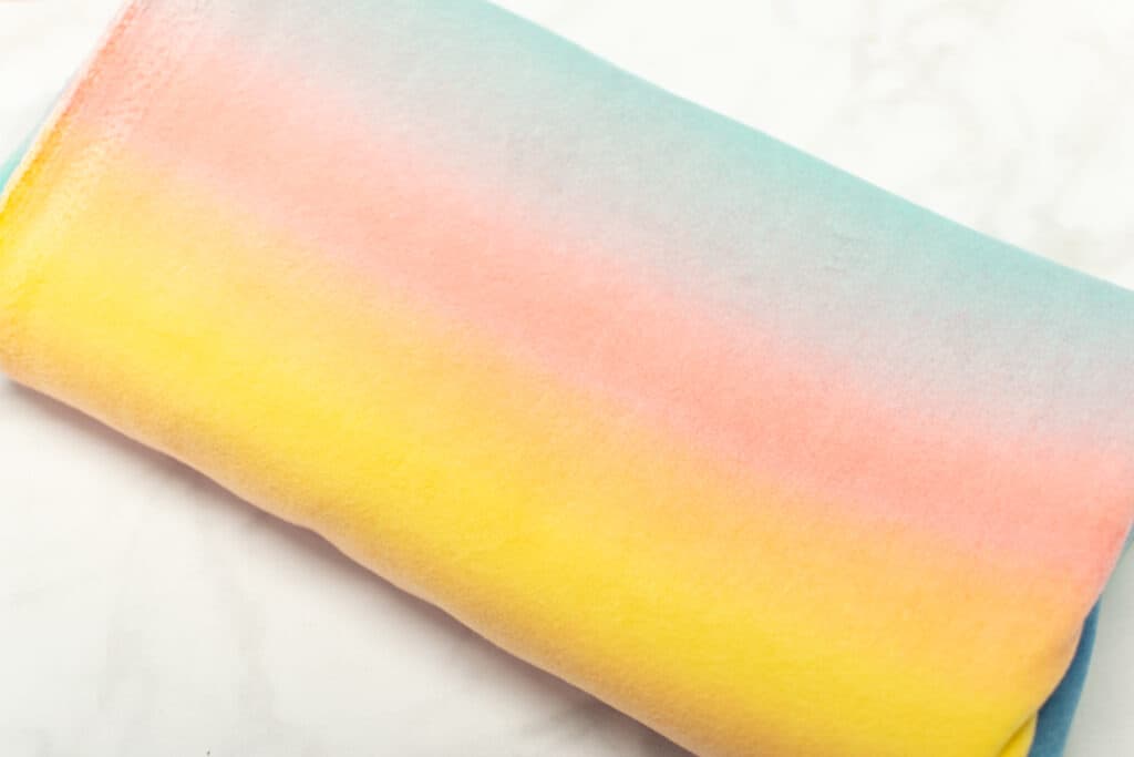 yellow, pink, and blue ombre fleece fabric on a white background